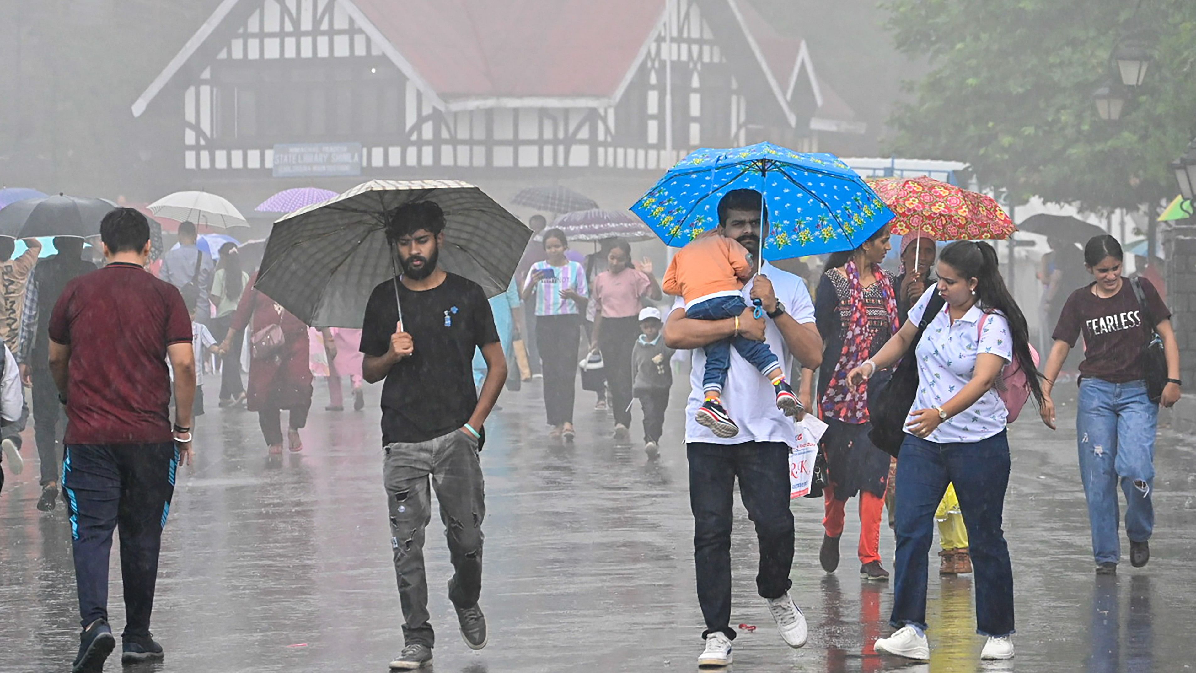 <div class="paragraphs"><p>Pedestrians on a street amid rain, in Shimla,</p></div>